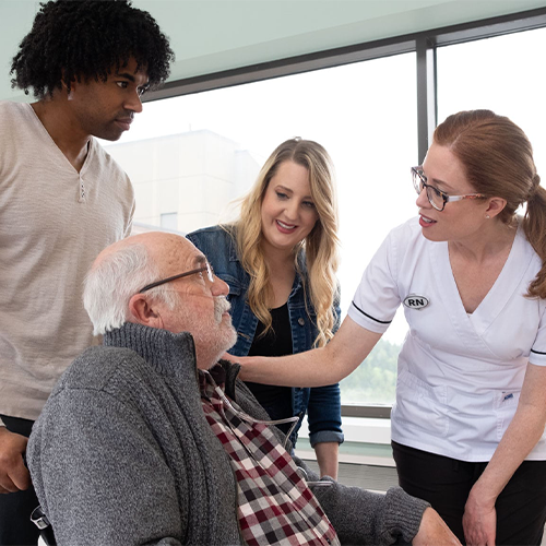 Nurses talking to an elderly patient