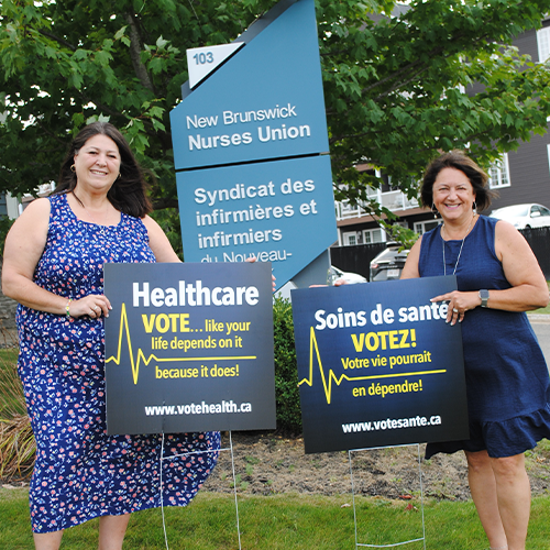 Nurses standing and holding a banner